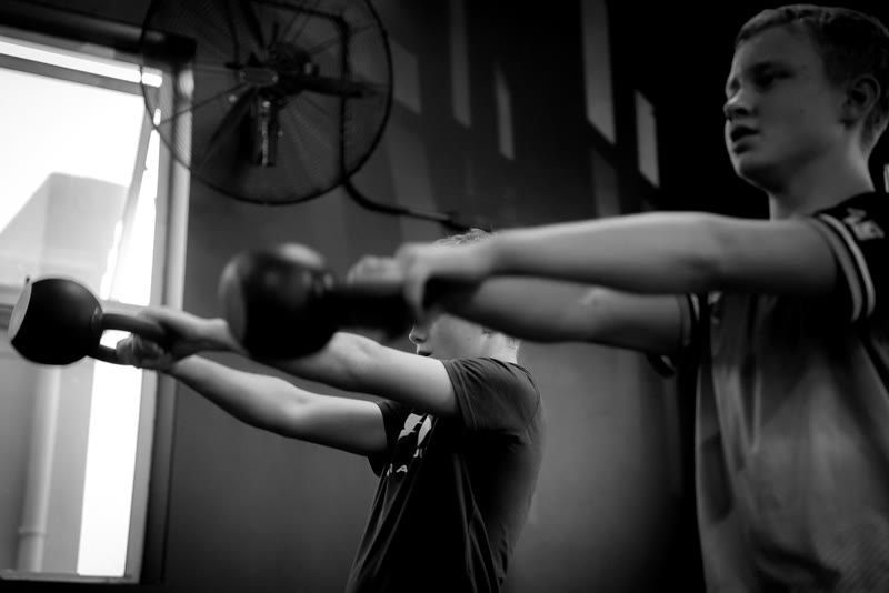 Junior athletes working through kettlebell swings